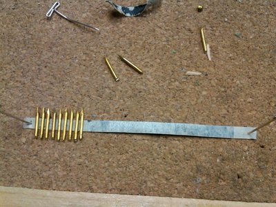 Small brass brads with the head cut off put on a piece of masking tape.