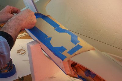 Gerry lining up the masking tape and paper. He applies the frisket film right over the markings that traced right on to the airframe with pencil.